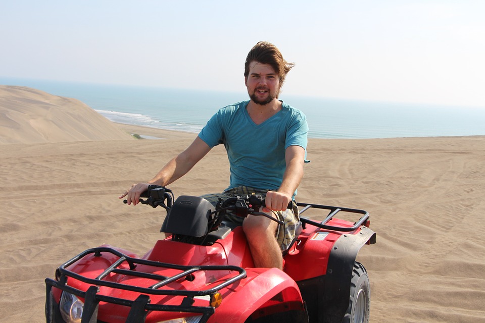 Young man on an ATV at the beach.