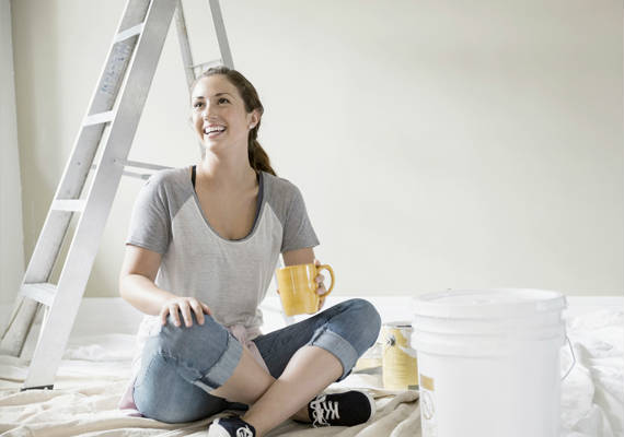 Lady happy to paint her new home interior a different color.